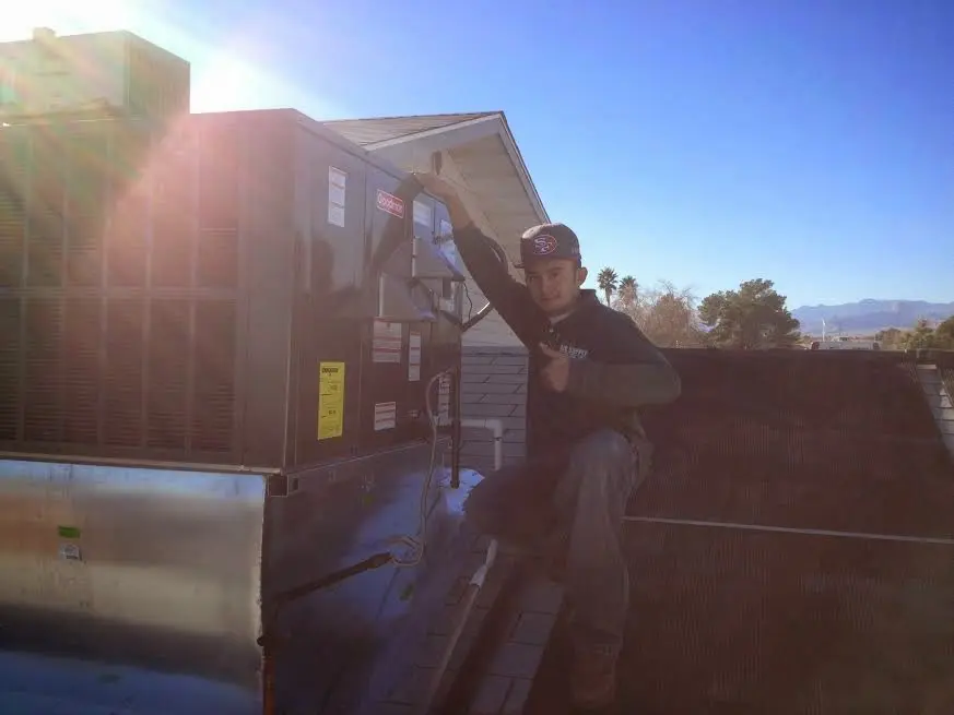 HVAC technician performing Air Duct Repair on a rooftop unit in Horizon West
